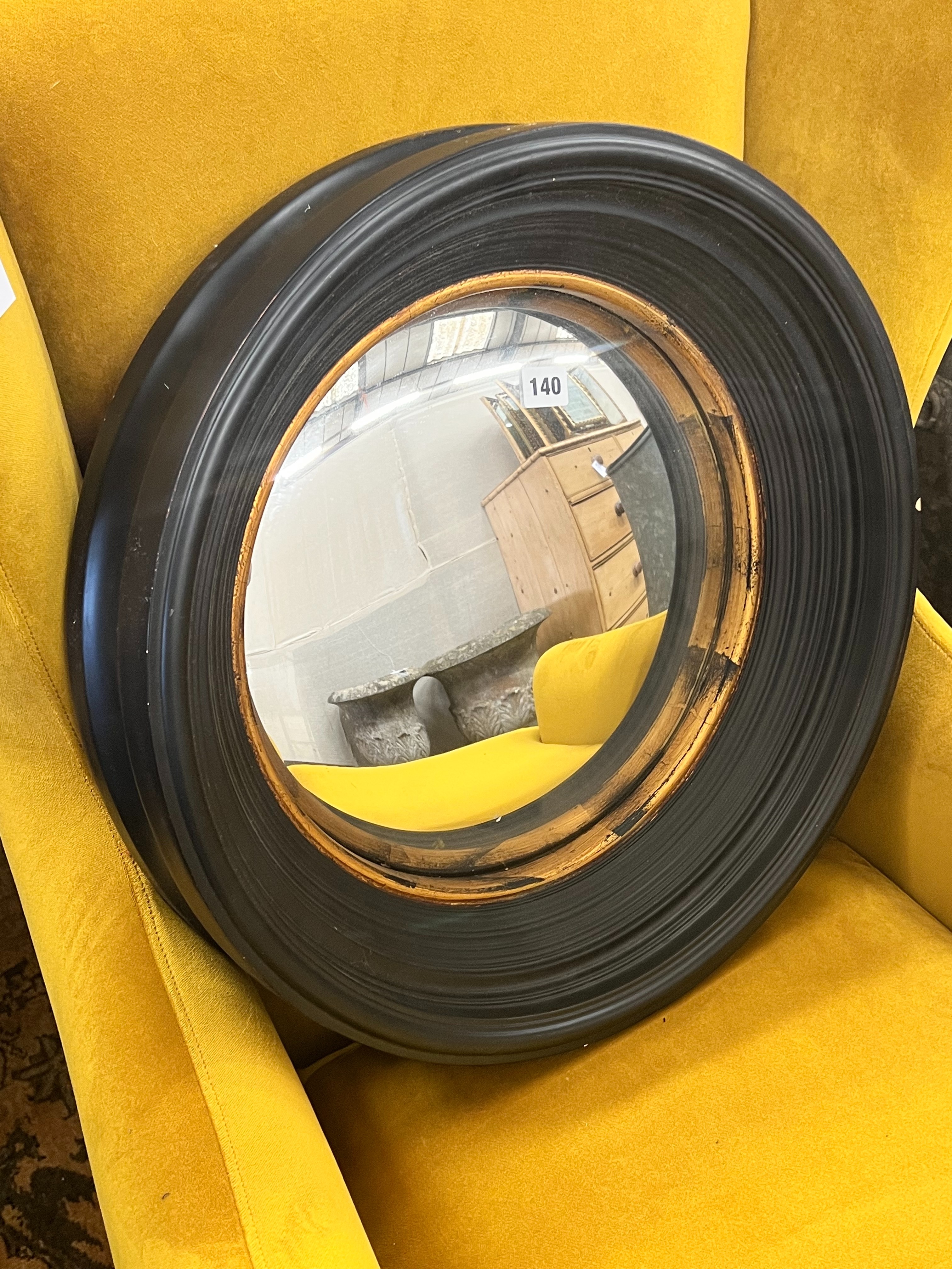 A contemporary black painted convex wall mirror with gilt slip, diameter 51cm